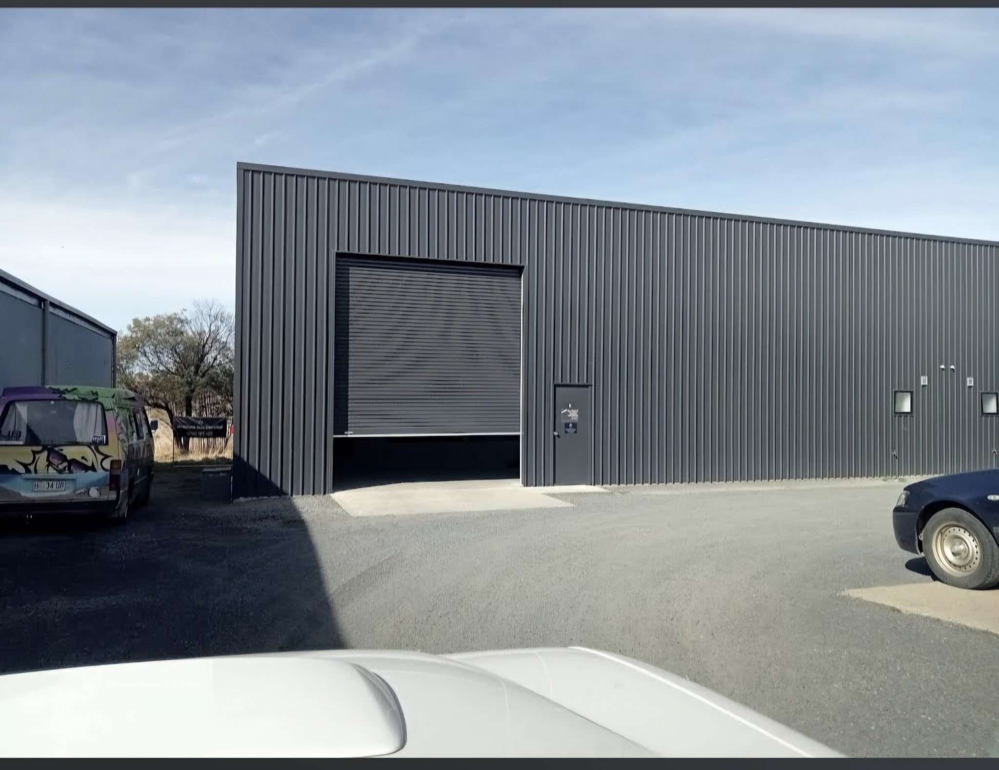 The Jindabyne Auto Electrical workshop, a charcoal steel shed on Lee Ave with the roller door open